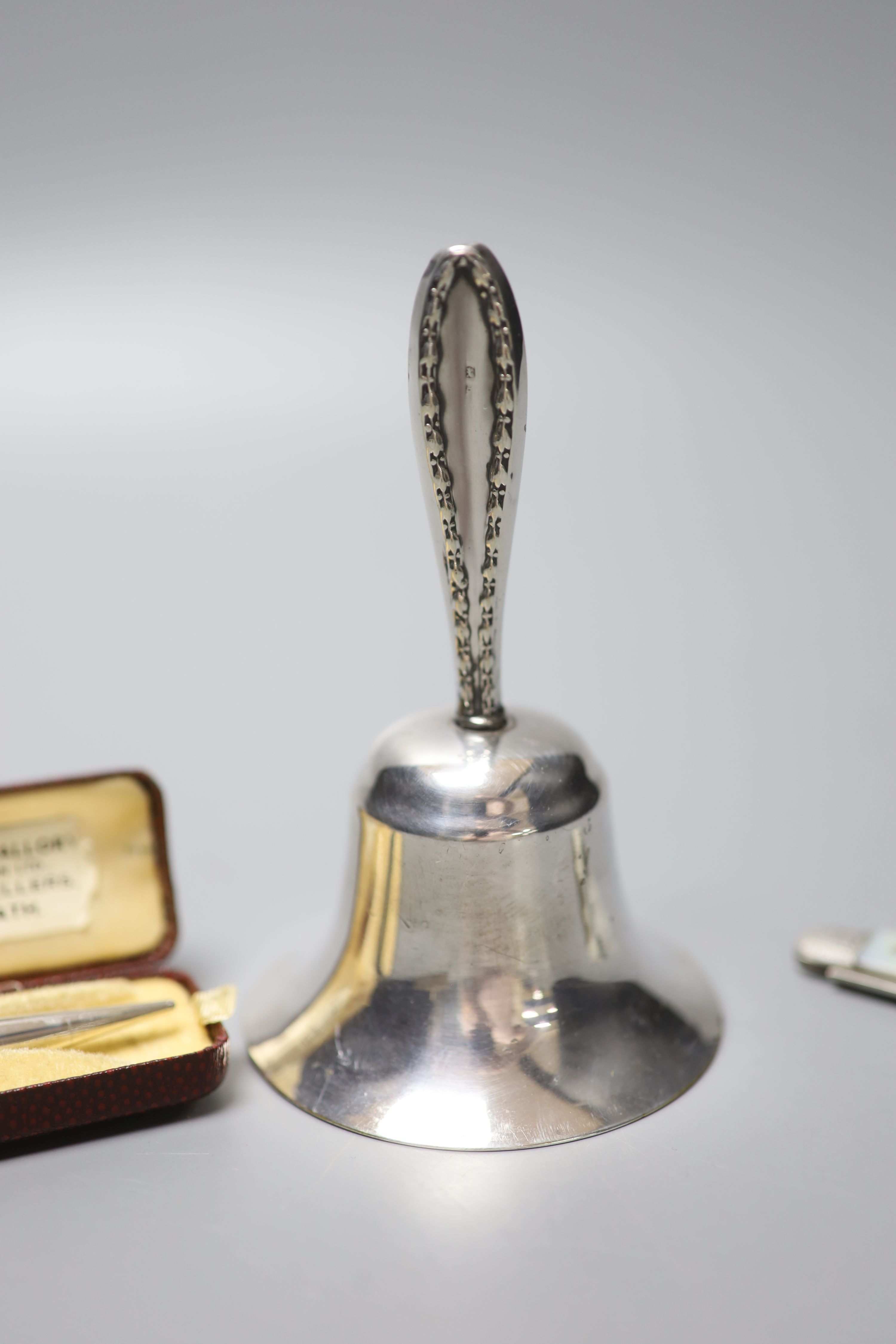 A silver handled bell, 11.5cm, a silver cased Yard-O-Led pen and a mother of pearl handled silver fruit knife.